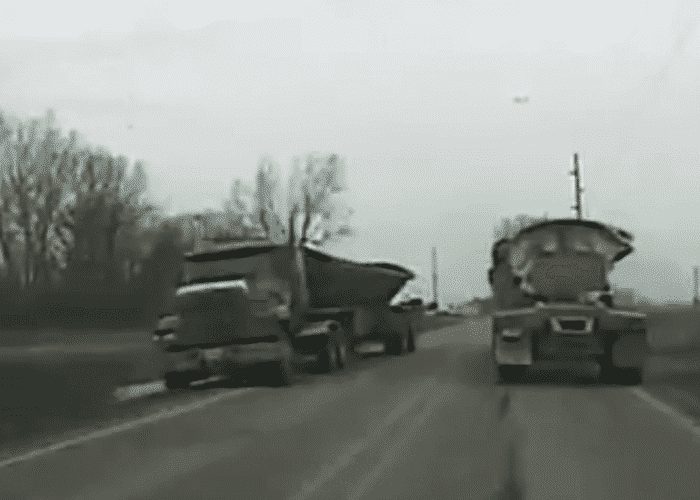 VIDEO: Suspect Fleeing Police Has Near Miss With Two Trucks