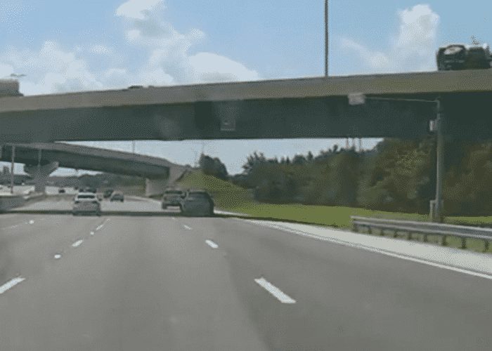 VIDEO: Truck Overturns On Overpass And Rains Rocks On Car Below