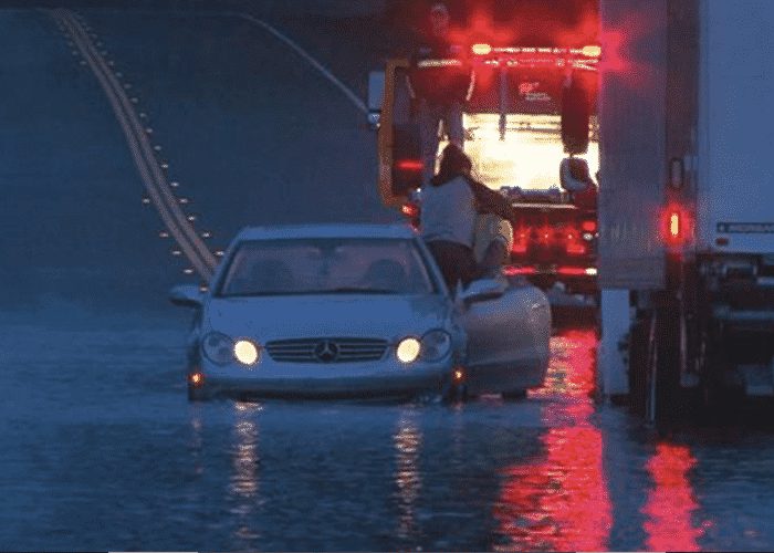 Truck Driver Gives Flood-Stranded Motorist A Piggyback Ride To Safety