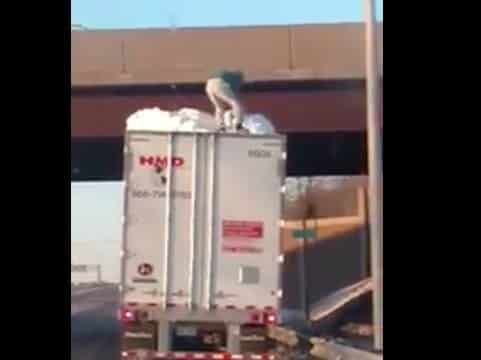 VIDEO: Trucker Climbs On Top Of Trailer To Clear Snow With A Rod
