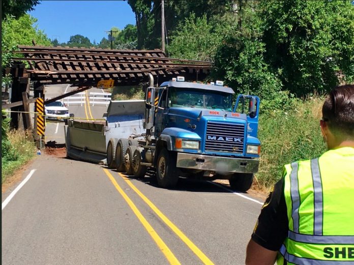 Dump Truck Driver Forgets To Lower Bed, Twists Train Trestle