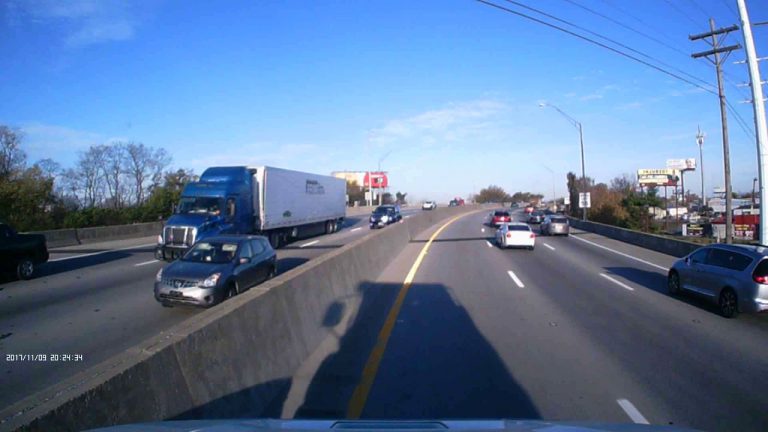 VIDEO: Car crashes into the side of a semi truck and then slams into the median barrier
