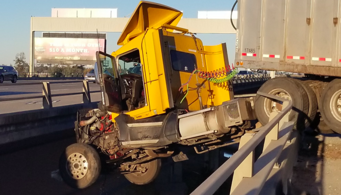Big rig dangles off I-5 overpass after swerving to avoid pickup