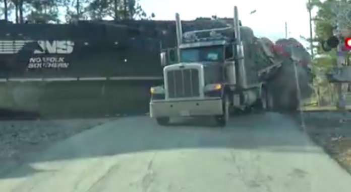 Watch as a trucker leaps from his rig seconds before it gets decimated by a train