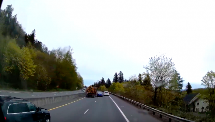 VIDEO: Car driver tries lane splitting to get in front of a logging truck