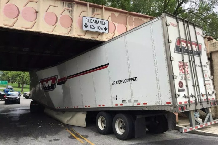 Tractor trailer stuck under railroad bridge