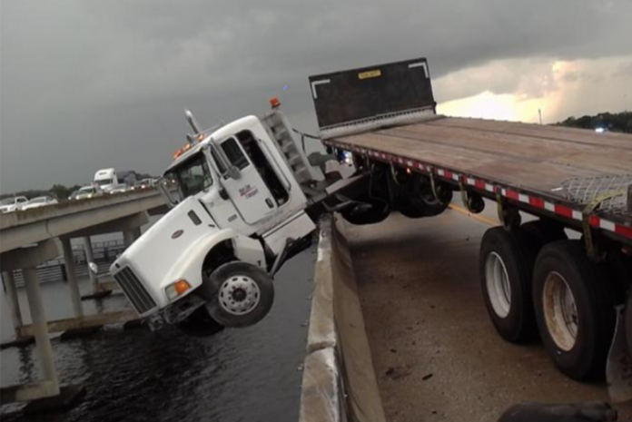A truck driver says that he was cut off by another vehicle just before the crash that left him dangling precariously from a Florida bridge this morning.