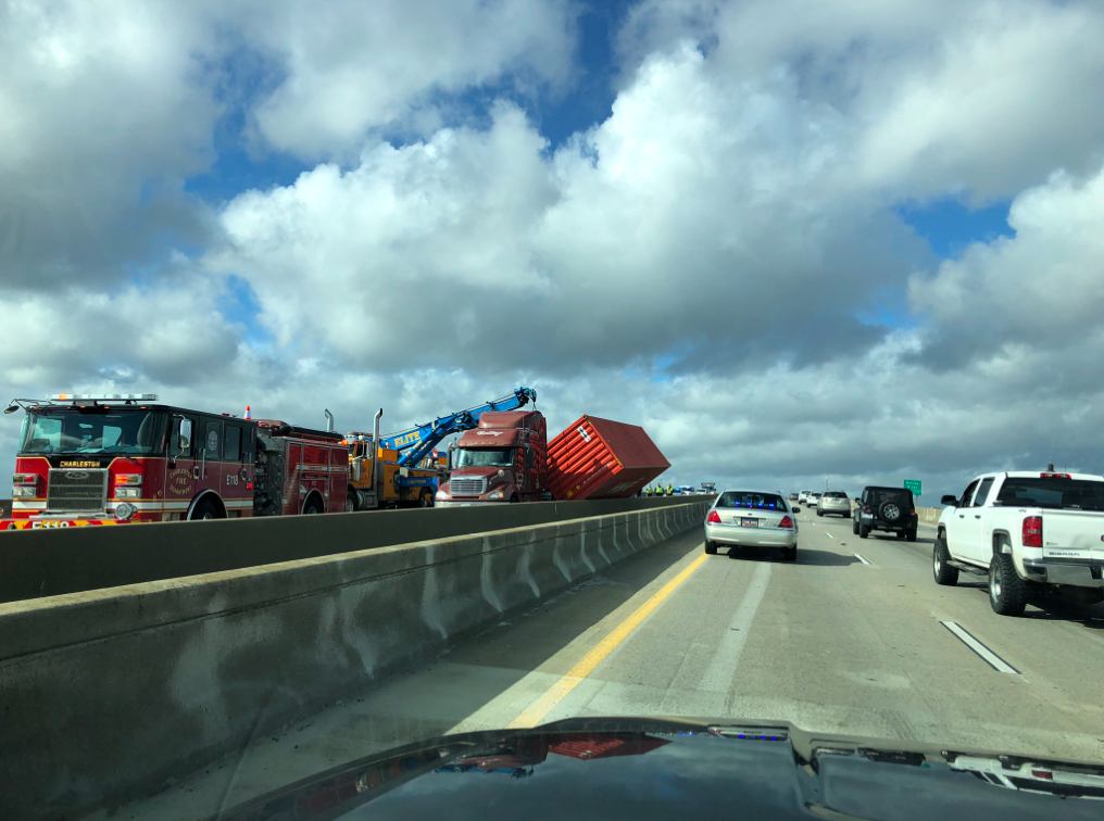 Winds topple empty container truck on bridge