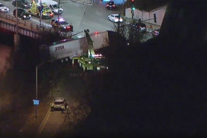 Trucker survives crash that left big rig dangling from overpass