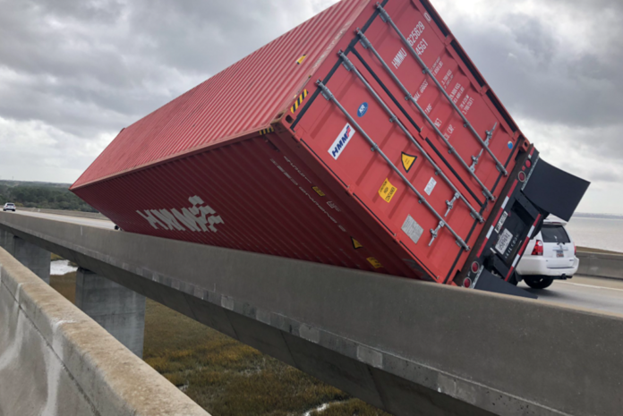Winds topple empty container truck on bridge