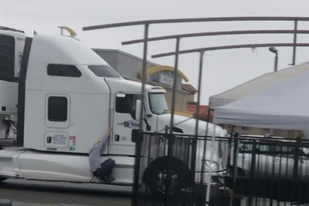 Man flees from fight by hopping on semi truck side steps in bizarre video