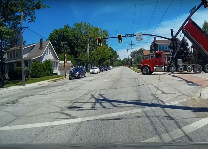 Dump truck tangles with traffic light