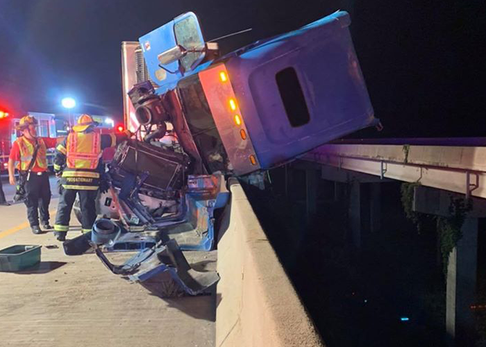 Crash leaves semi teetering from bridge, injures family of four