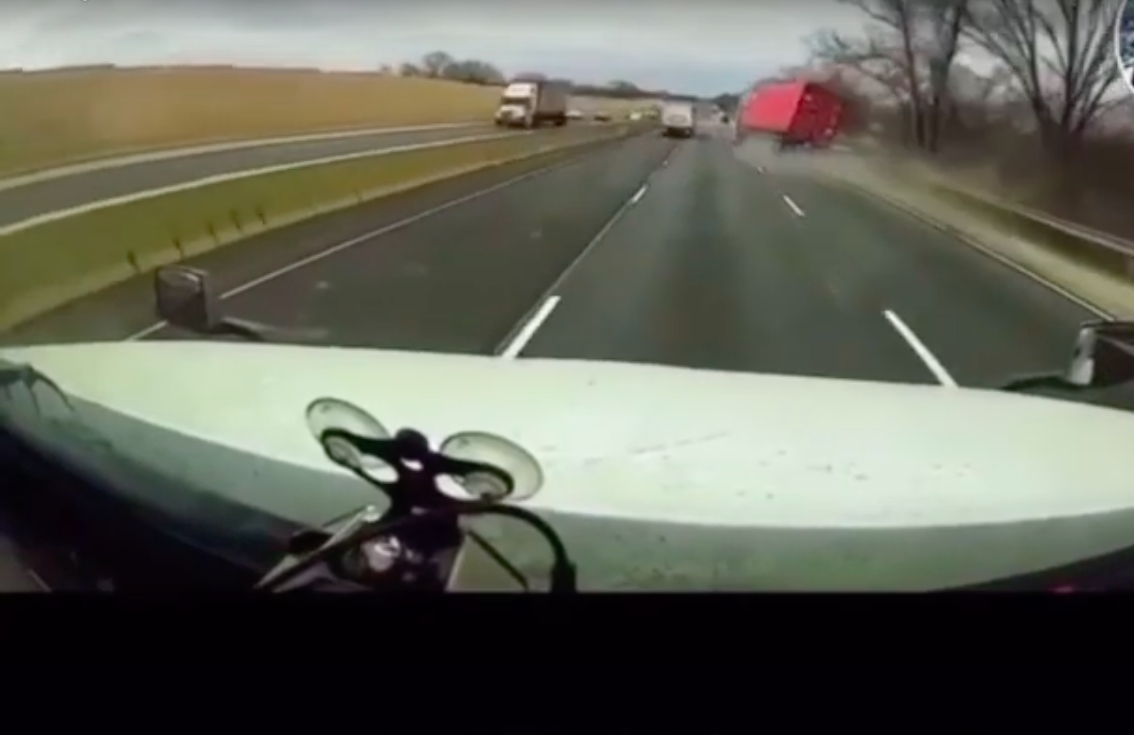 VIDEO: Mustang driver tries to zip between two semis, causing one to capsize
