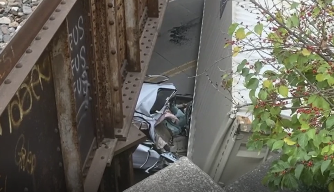 Car crushed when container falls from passing semi truck