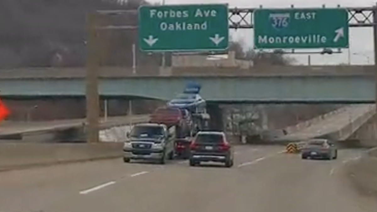 VIDEO: Car hauler loses just a little bit of his load to overpass