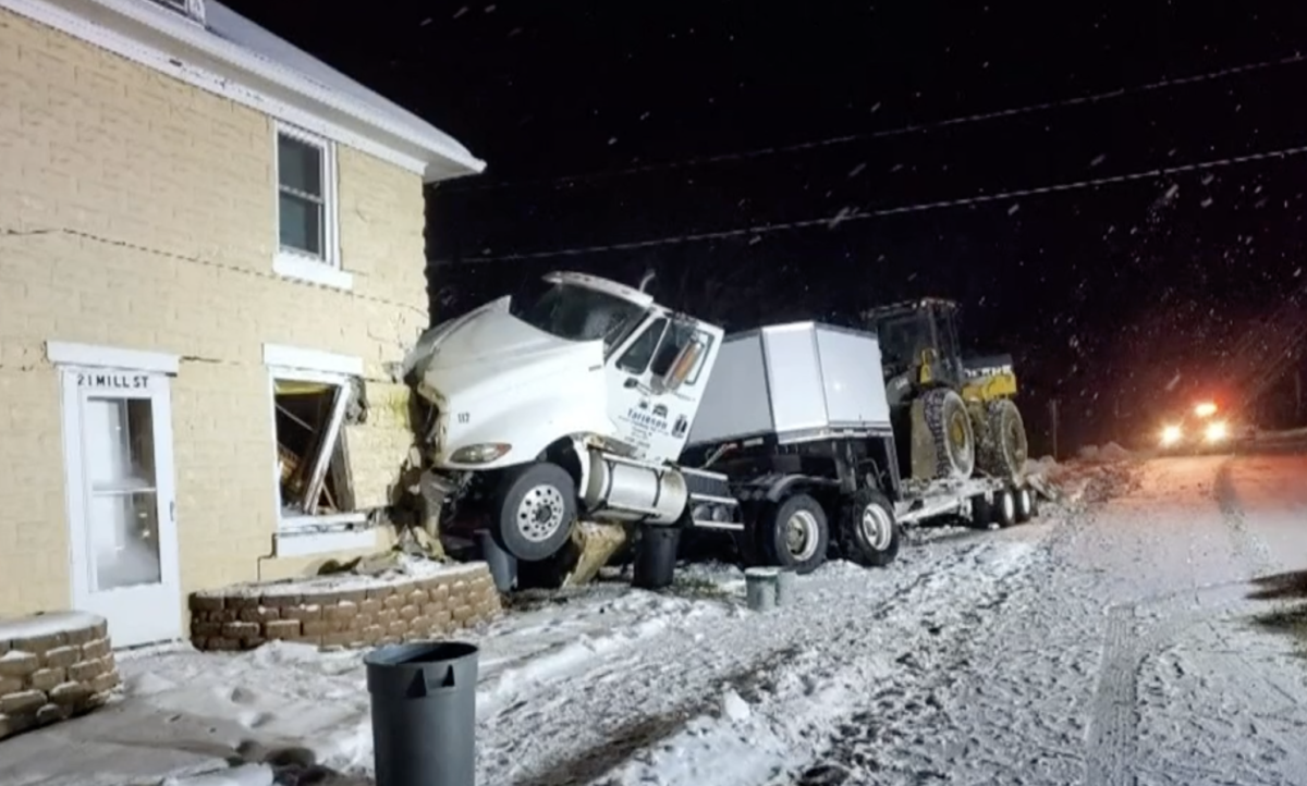 Snow-slick roads send semi truck into side of house 