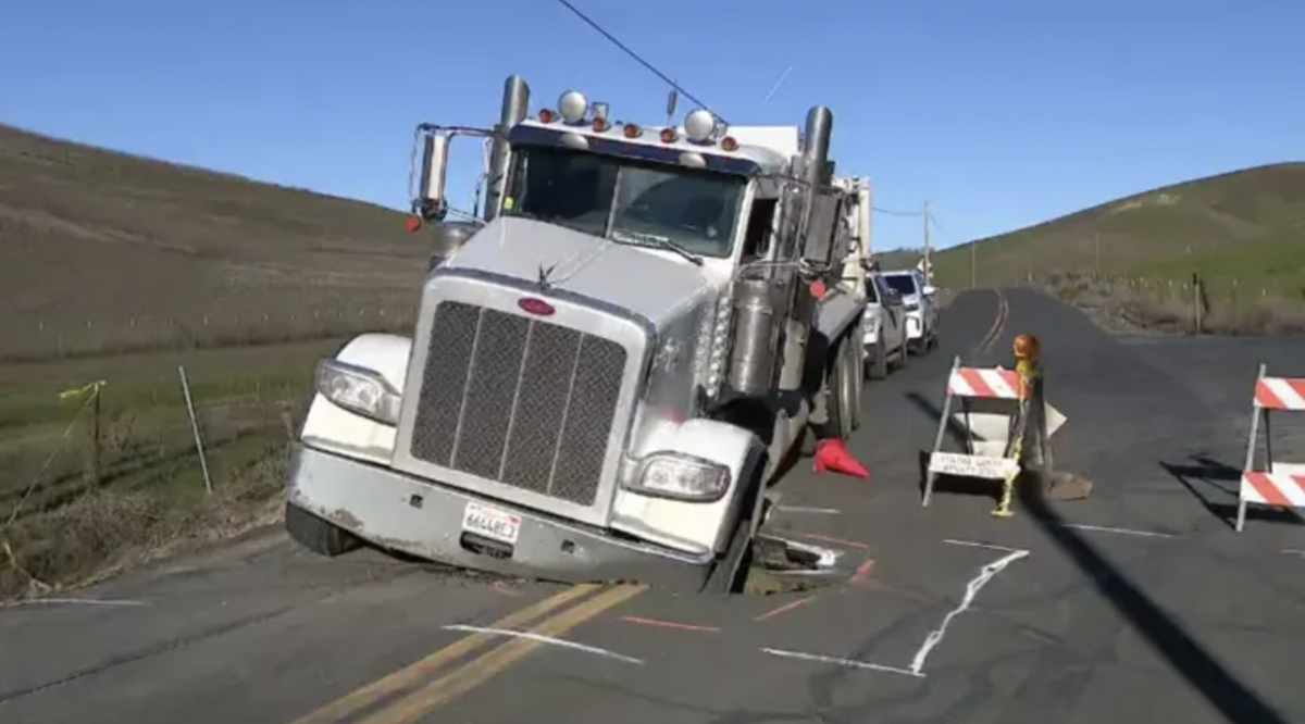 Dump truck falls into sink hole after ignoring road closure 