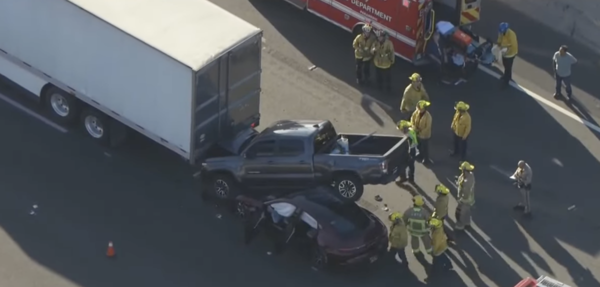 Pickup wedged beneath trailer after driving up & over Porsche 