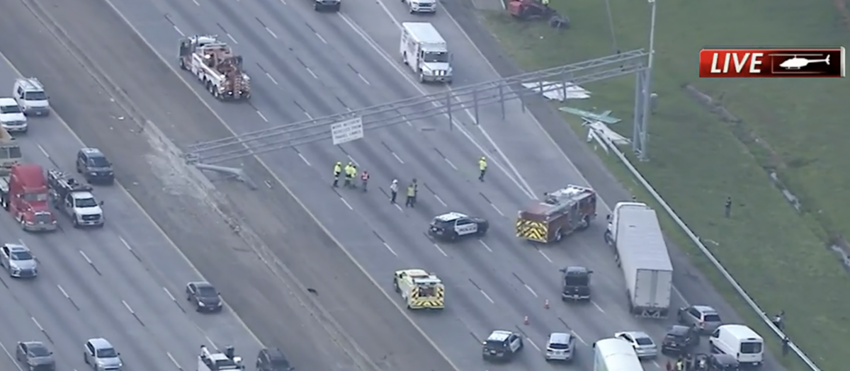 Dump truck takes down highway sign with raised bed 