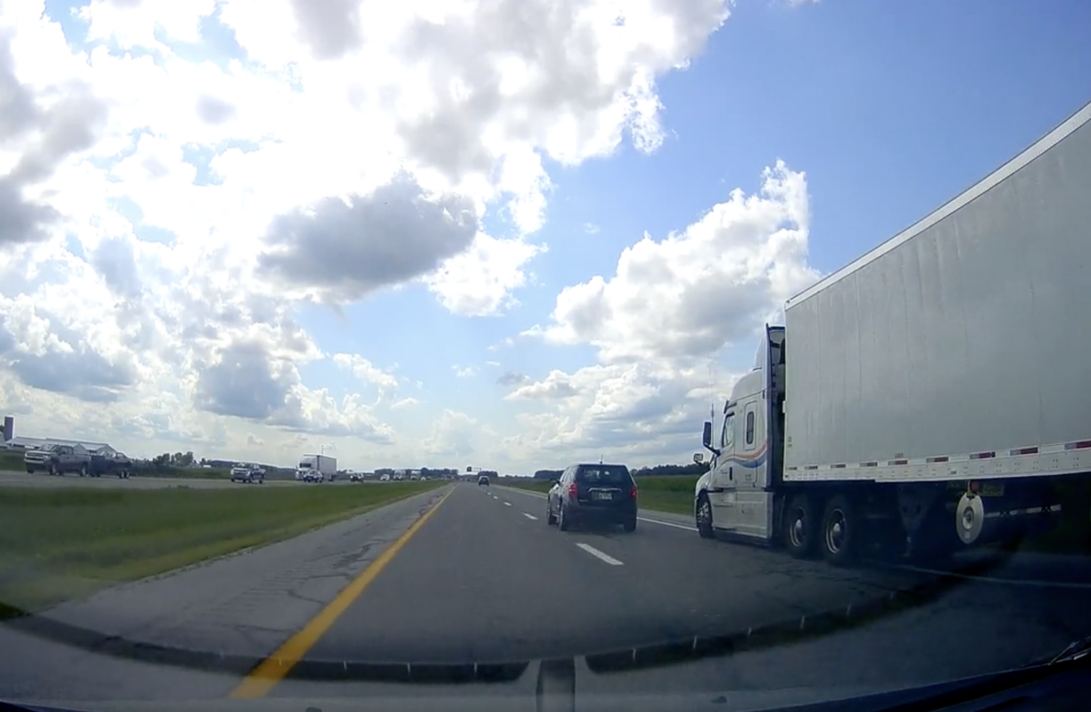 VIDEO: Trucker cut off by clueless car driver takes to the shoulder to prevent a big wreck