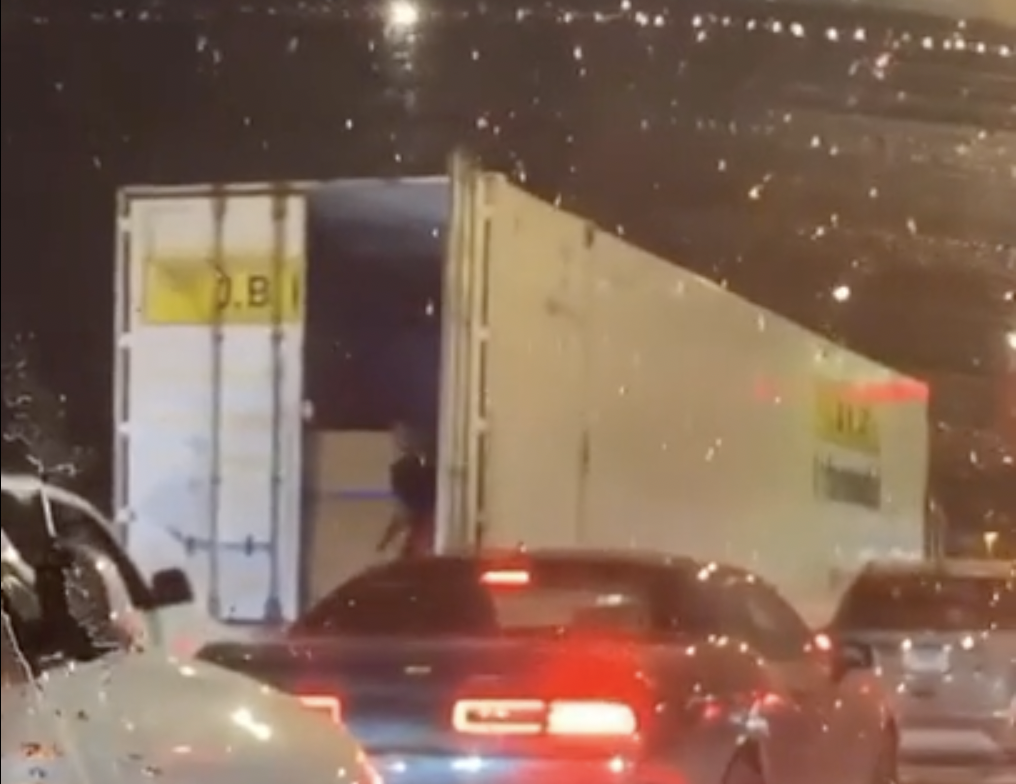 Video appears to show person stealing cargo from truck stuck in traffic