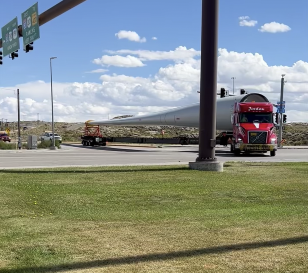 Watch as a trucker makes a tight turn while hauling a 170 foot wind turbine blade