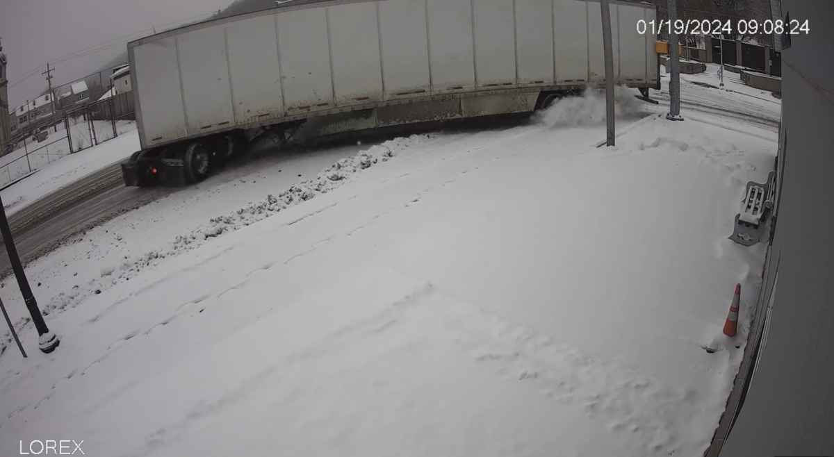 Security cams catch semi truck jackknifing down a hill, nearly hitting ambulance building