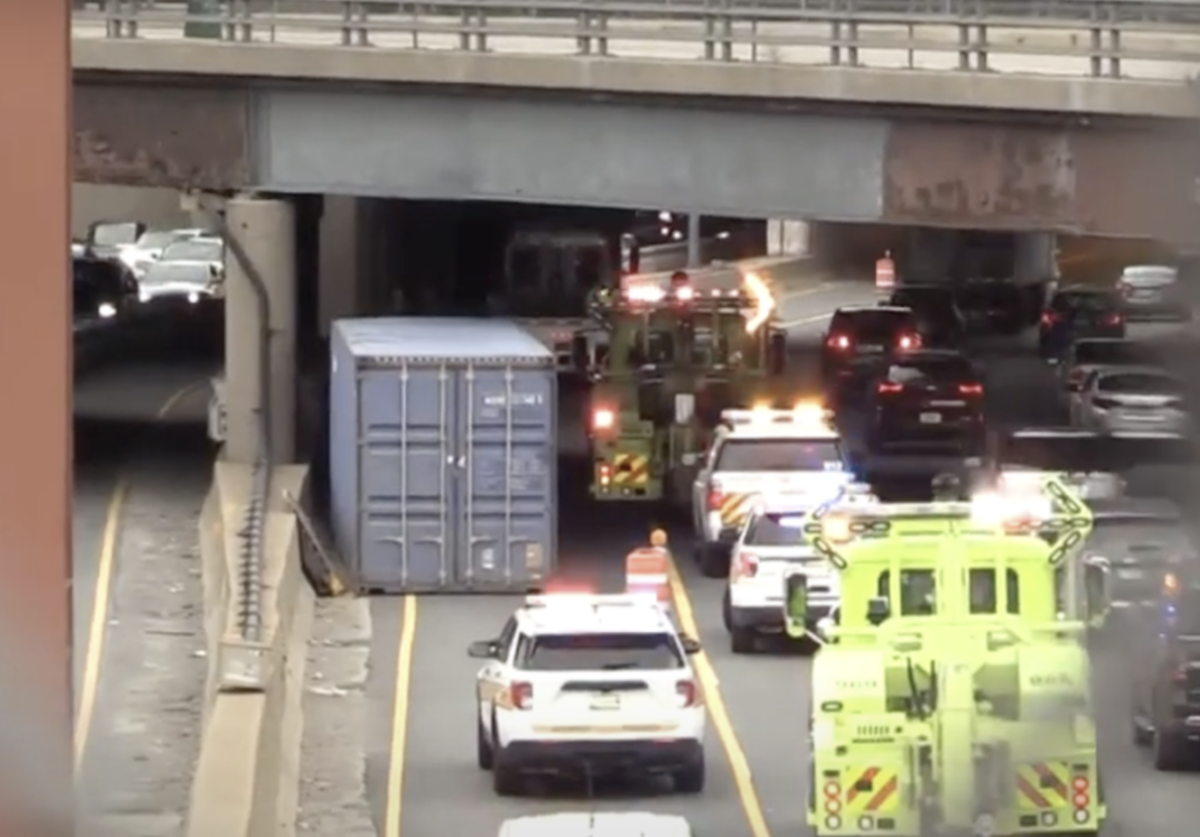 Shipping container falls off trailer, injuring two