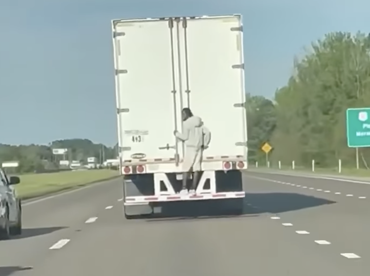 Man filmed just chilling on the back of a moving semi truck