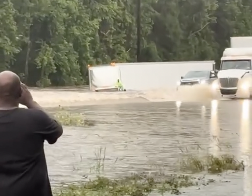 Video shows driver clinging to cab as semi sinks into floodwaters