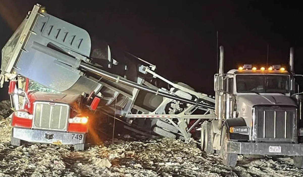 Raised bed of one truck tips and crushes driver inside of another