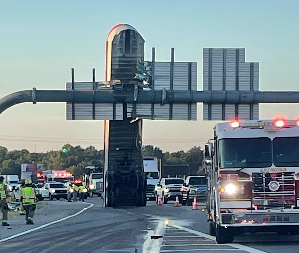 Trucker leaves trailer leaning against highway sign