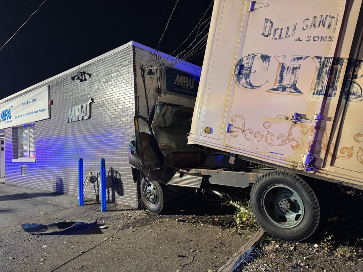 Antique truck fell off tow truck on highway, collided with building in New Jersey