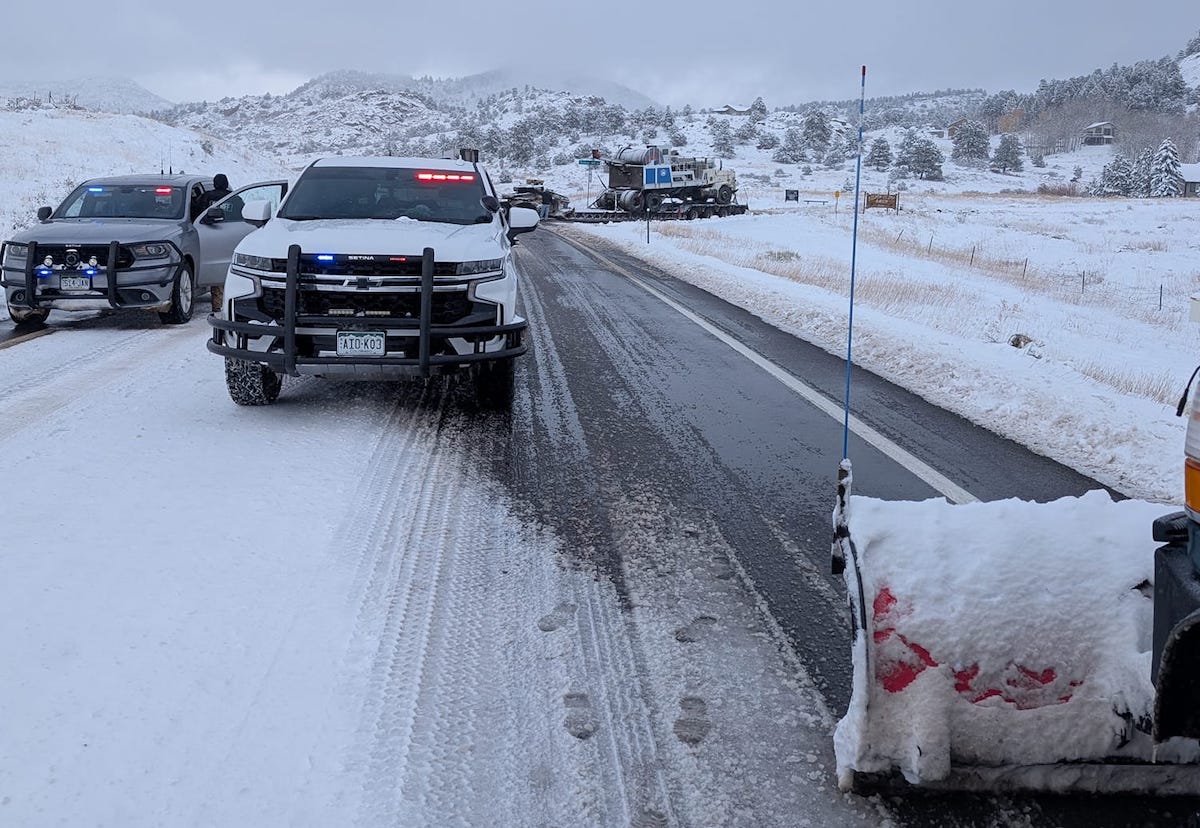 Locals plow roadway for chain-less trucker to back up in the snow