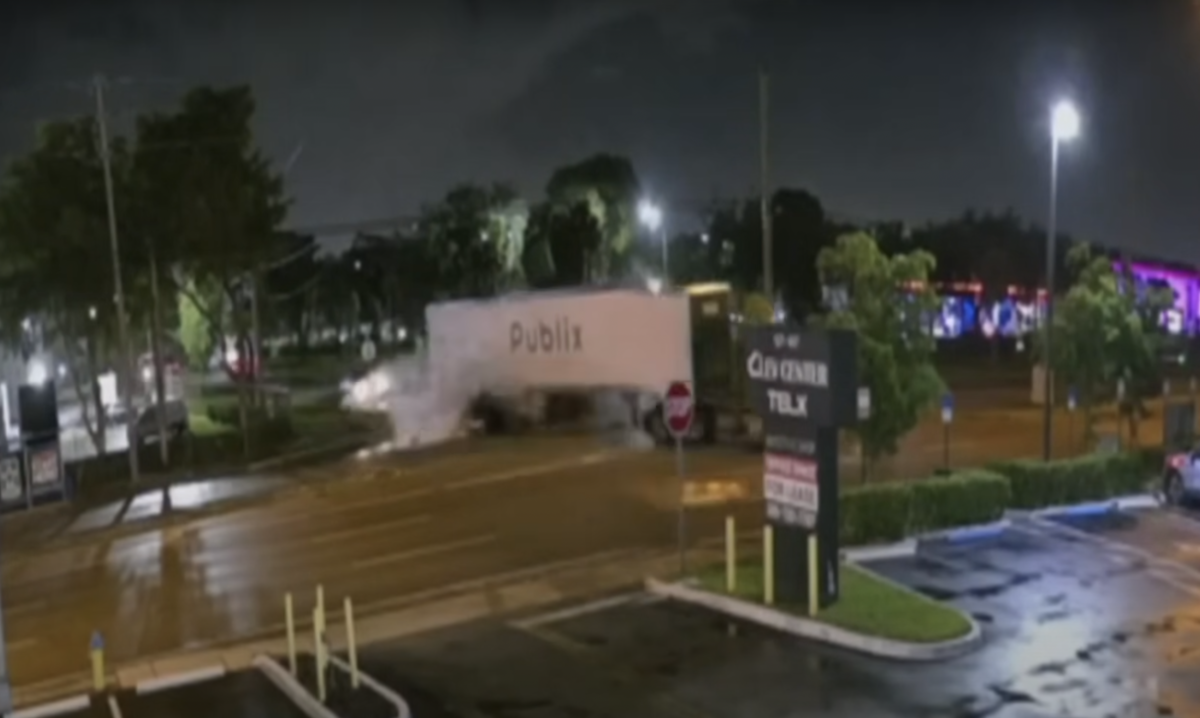 Surveillance video catches pickup crashing under turning semi truck at high rate of speed