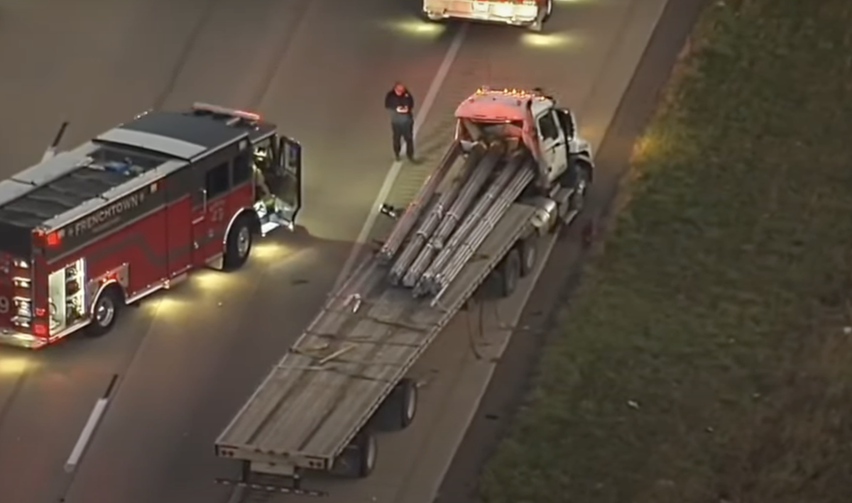 Trucker pinned by own load of steel pipes manages to call 911