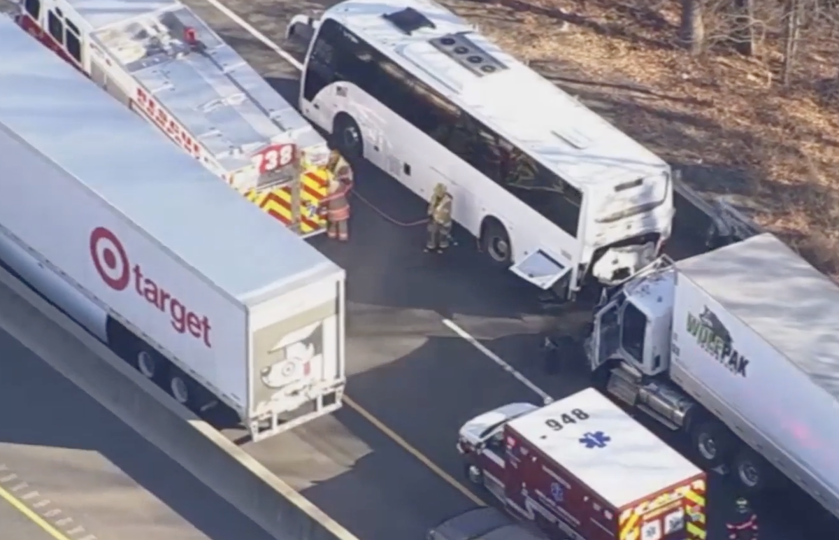 13 people hurt in semi truck crash with broken down bus transporting military personnel