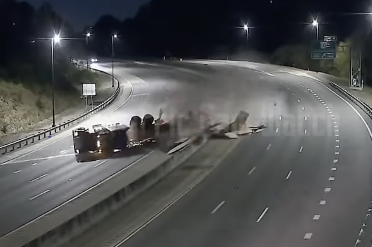 Arkansas DOT cams catch flatbed truck rolling on a curve, spilling load all over interstate