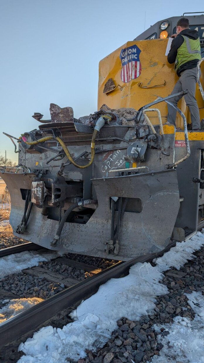 Semi truck and train damaged in collision involving trailer full of rocks