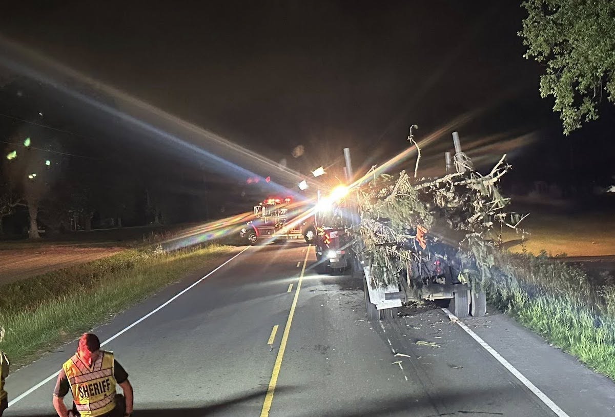 Lone log trailer left blocking two lane road