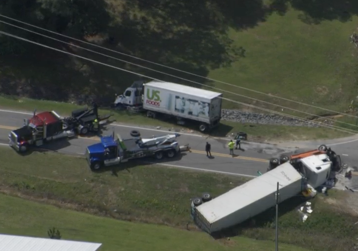 Four wheeler waiting to turn hit by tractor trailers on both sides of the highway