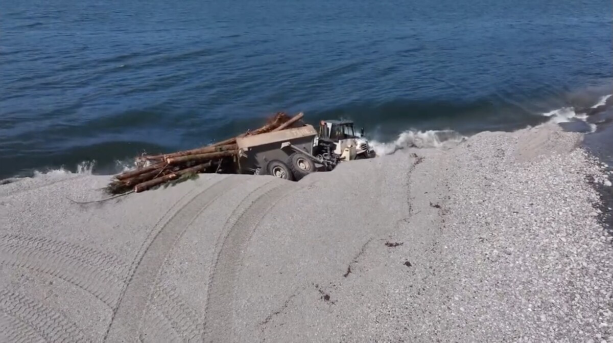 Video shows shoreline collapsing under commercial vehicle, leaving truck driver to swim to safety