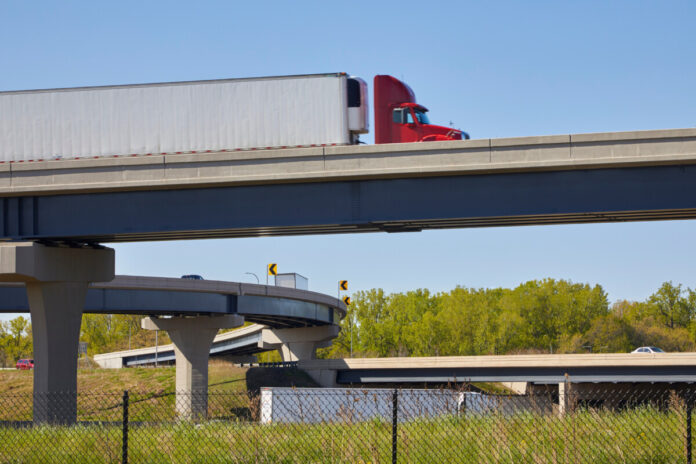 Large semi truck traveling over freeway bridge and interchanges near Minneapolis Minnesota