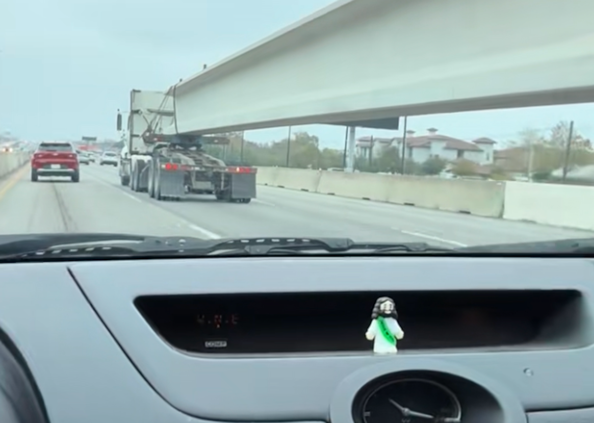 Watch a motorist change lanes underneath semi truck hauling a concrete beam from two POVs