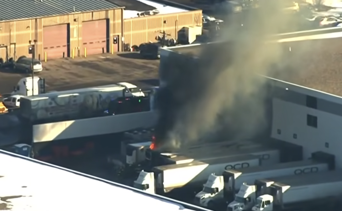 Multi semi truck fire spreads to building and traps employee in a cooler