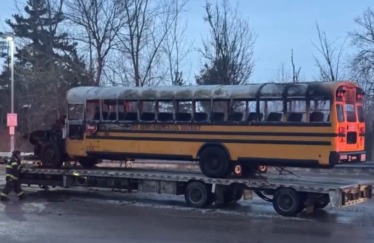 School bus goes up in flames on flatbed tractor trailer while parked at rest stop