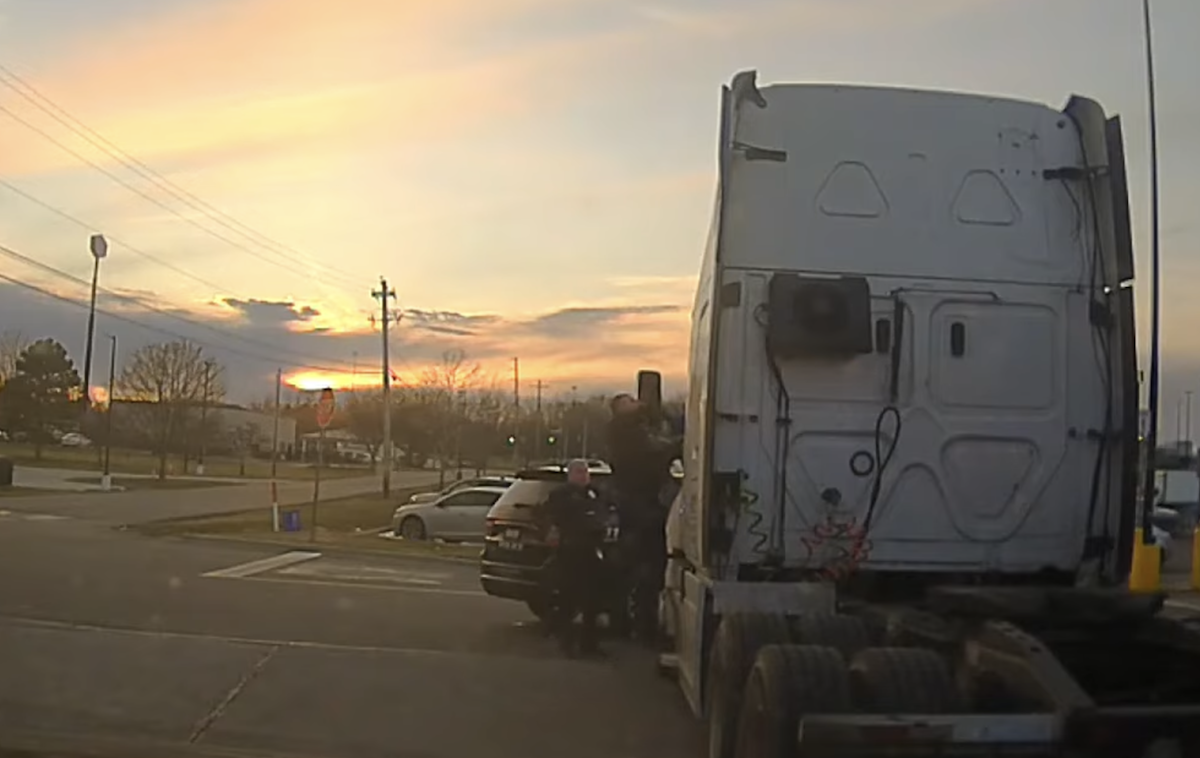 Body cam footage shows trucker accused of stalking speeding off with officer hanging off cab