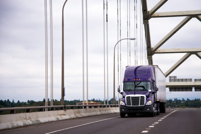 Image of purple semi truck on bridge