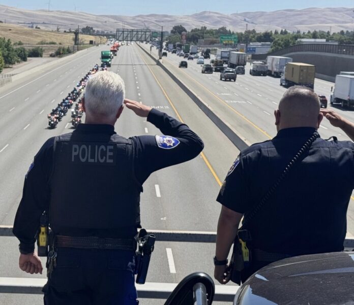 LPD image of officer saluting World Trade Center beam and escort.